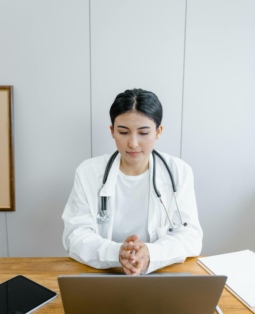 Doctor engaging in online telemedicine consultation via laptop indoors.